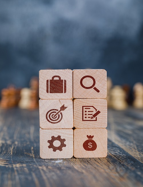 Business strategy concept with wooden cubes, chess figures on gloomy and wooden background side view.